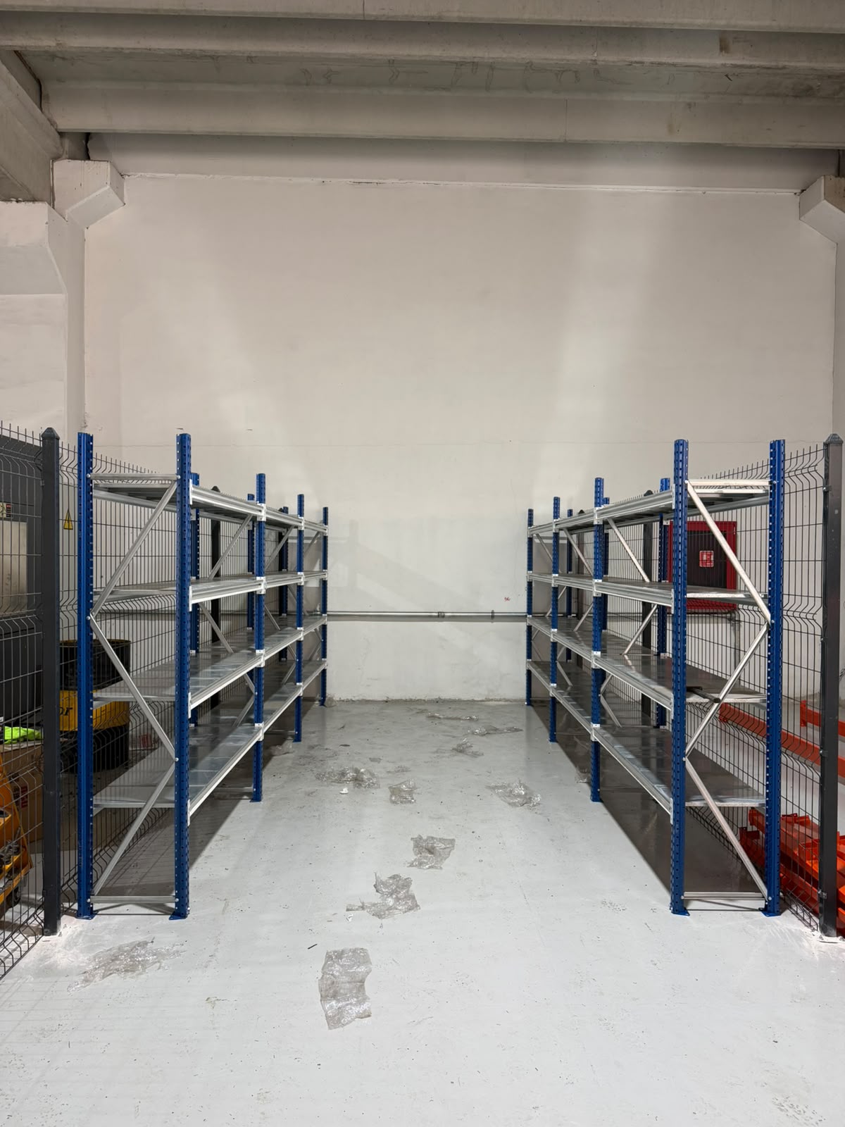 Depo içinde mavi taşıyıcılı ve metal raf tablalı raf sistemleri